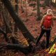Women in winter cloths and a backpack standing in an autumn coloured forest